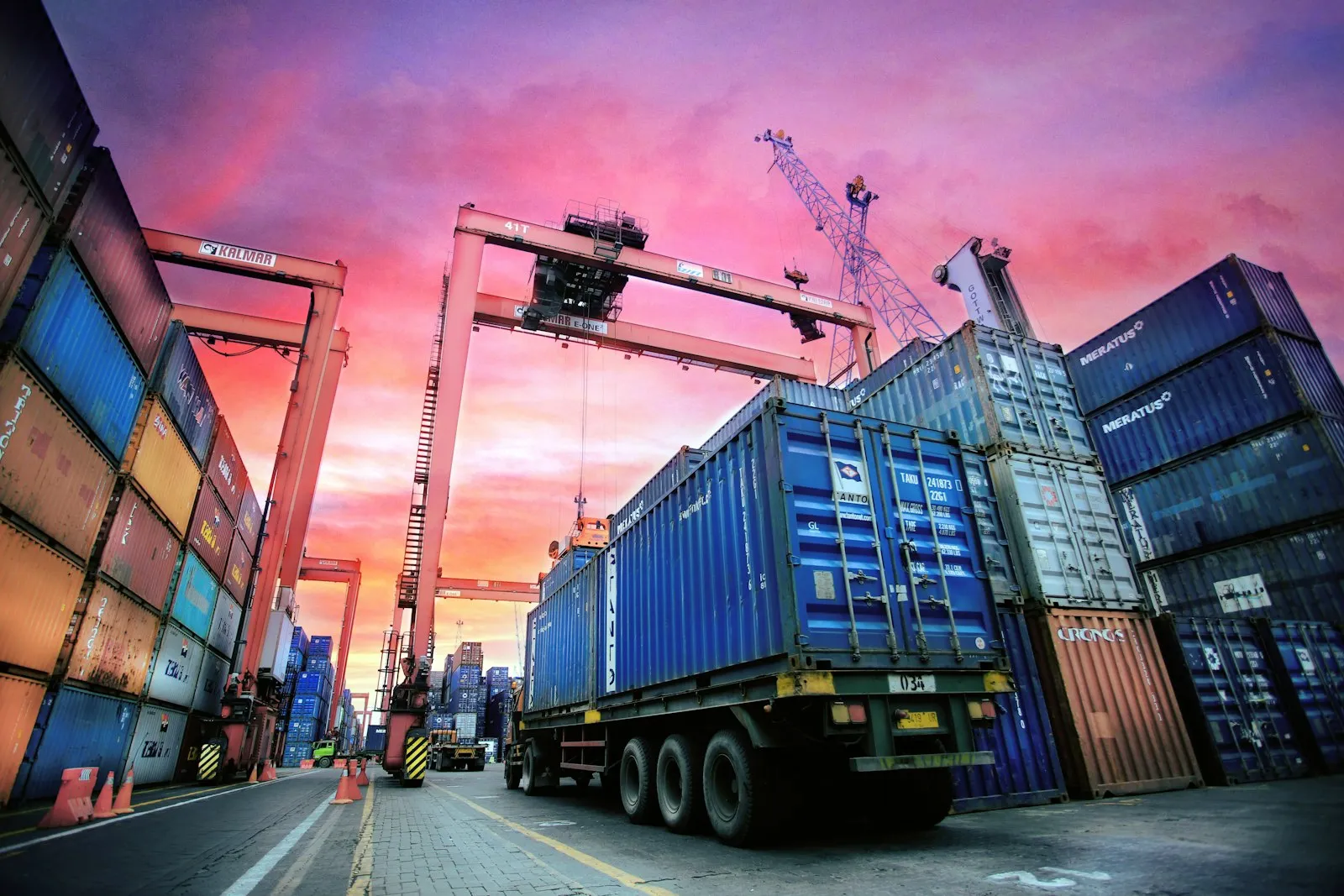Stacked sea containers in a port area at sunset